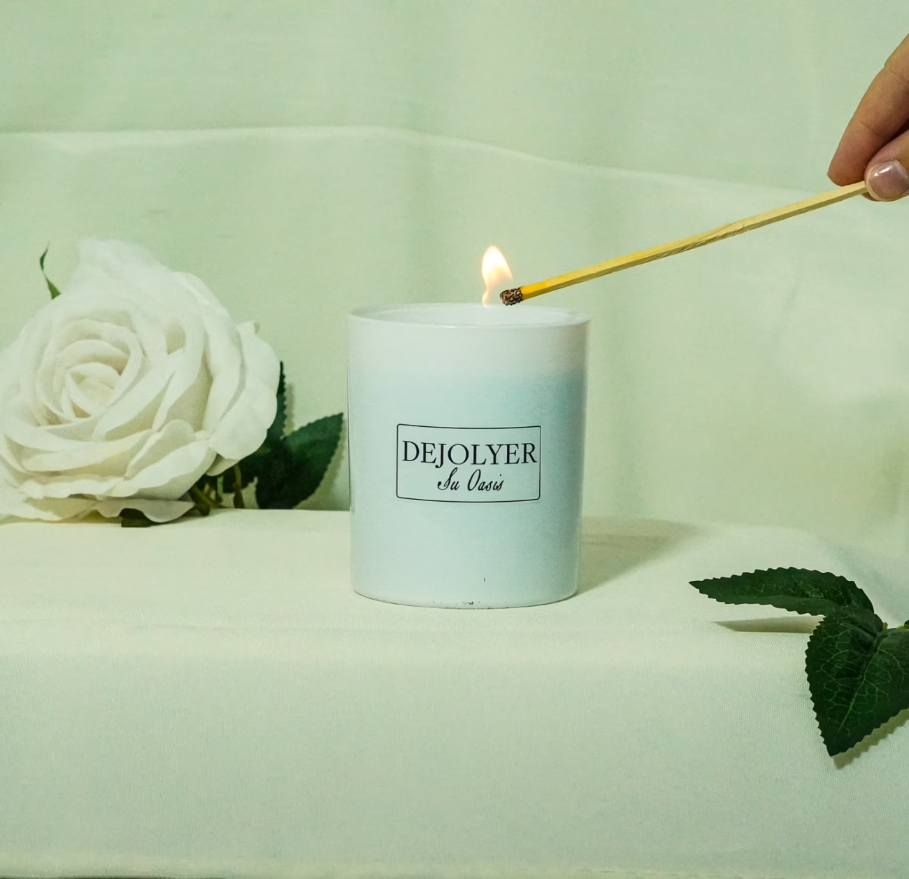 mano encendiendo un perfume en vela dejolyer